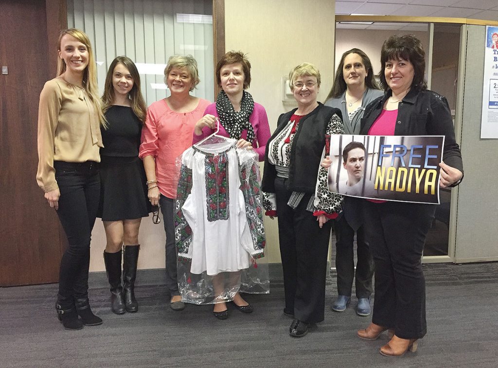 ROCHESTER, N.Y. – The Ukrainian community of Rochester, N.Y., has a “Free Nadiya Blouse” that it will gift to Nadiya Savchenko upon her release from illegal incarceration in a Russian prison and her return to Ukraine. Above, administrators and staff of the Ukrainian Federal Credit Union (from left), Galyna Dyakiv, Olga Bilokin, Lesia Chwesik, Tanya Dashkewich (chief operating officer), Christine Hoshowsky (president of the Rochester Ukrainian Group), Marijka Povoroznyk, Mariya Romanyk are seen with the blouse and a “Free Nadiya” poster, with which they sent off Dr. Hoshowsky to a rally in Greece, N.Y., for Republican presidential hopeful John Kasich on April 9.